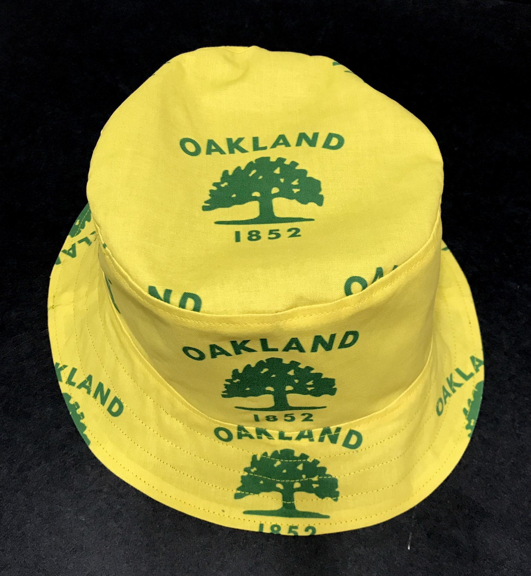 Front and top view of city of Oakland tree flag bucket hat, showing logo centered on top