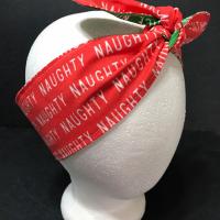 Christmas theme headband showing it tied on top on mannequin, red "Naughty" side showing
