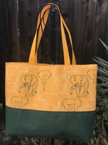 Tote bag, canvas bottom, green & white elephant outlines, hook & loop, one interior pocket, polypropylene straps