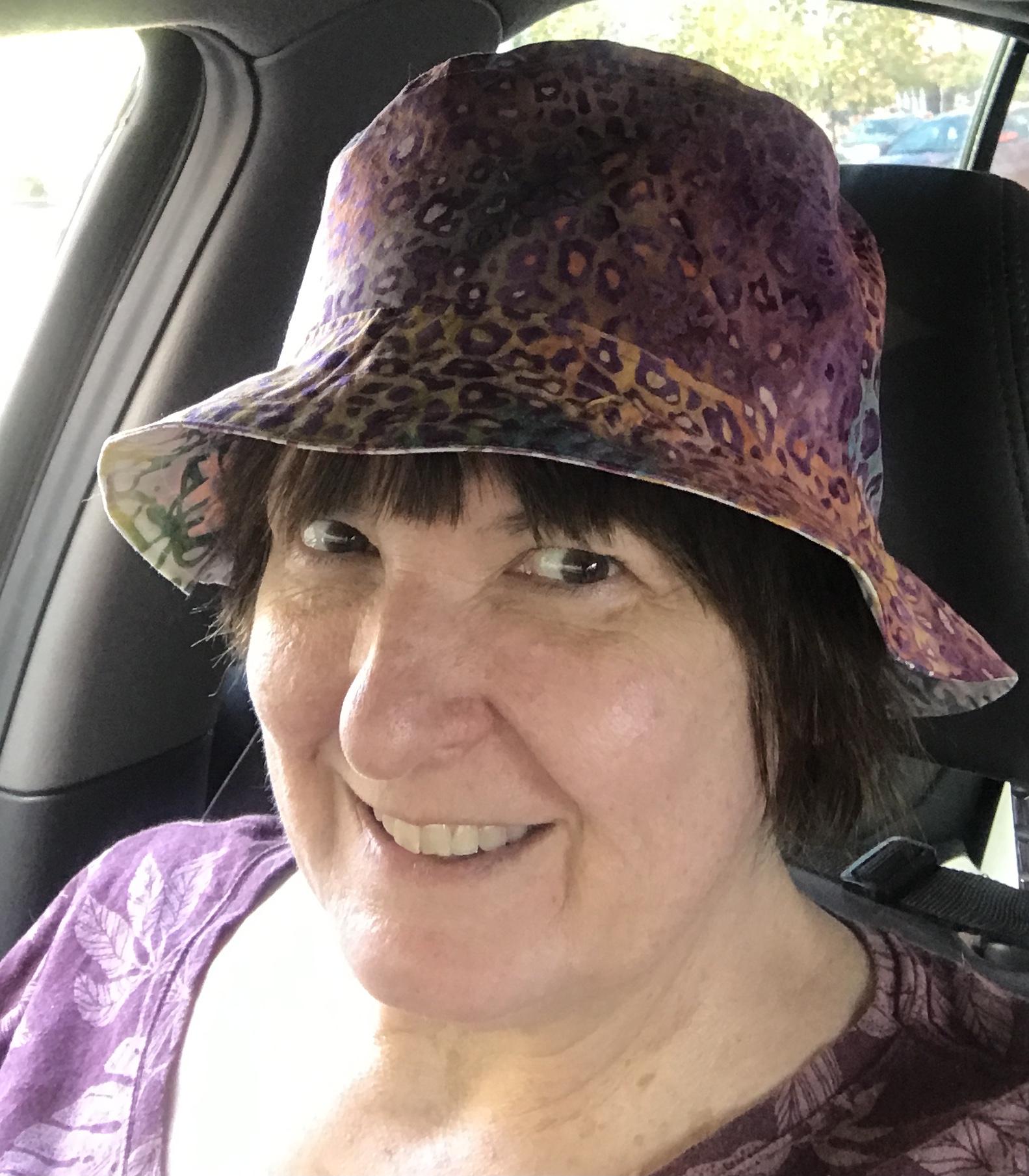 Woman wearing same hat in different fabrics, front view