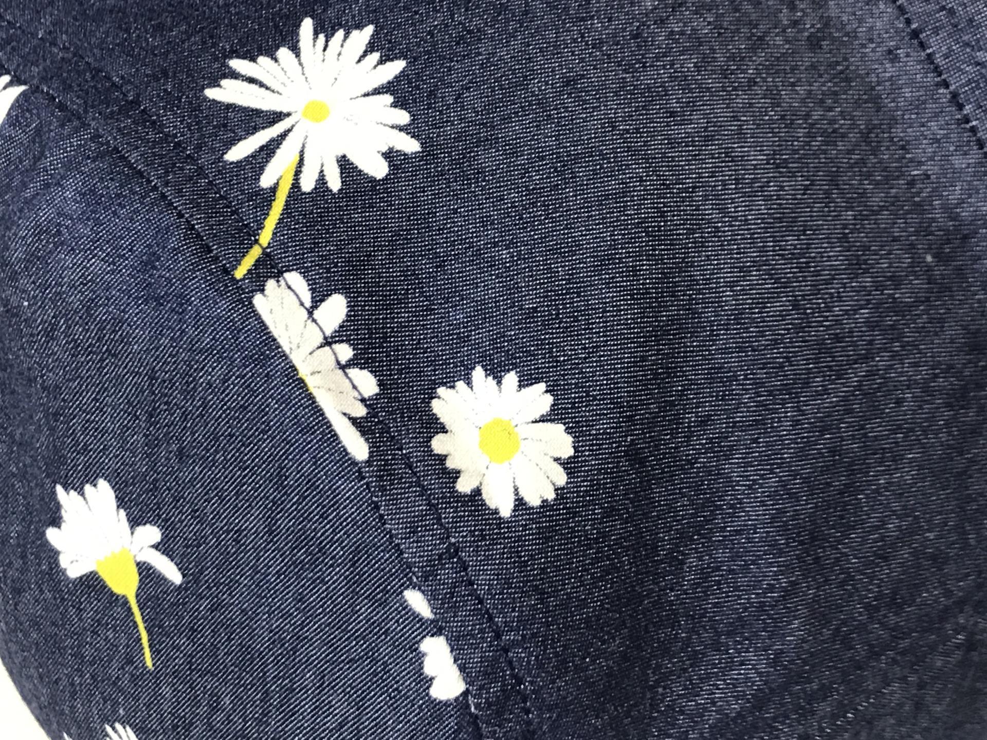 Close up showing small white daisies on denim