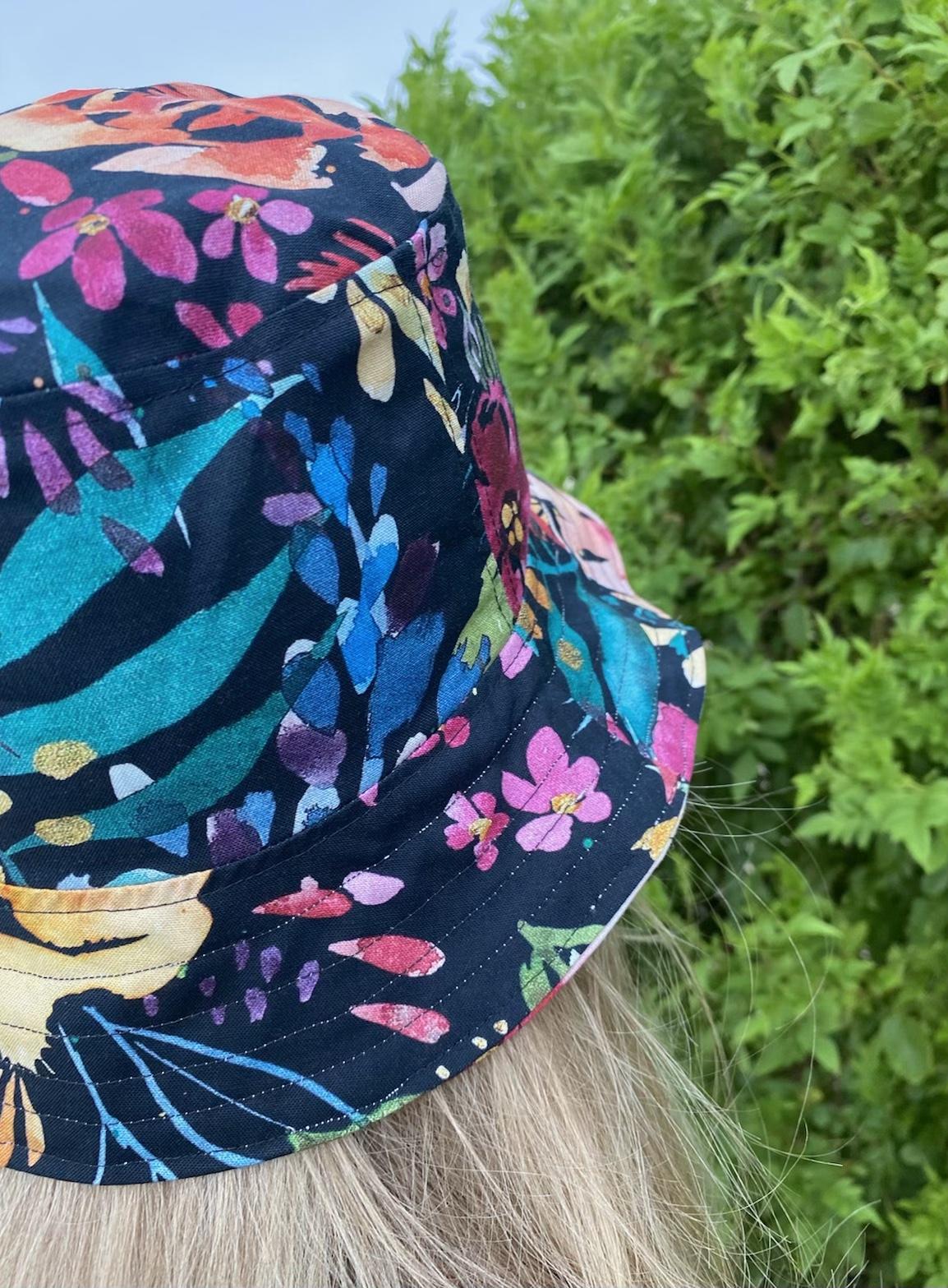 Rear side view close up of same hat in different print, worn by adult woman