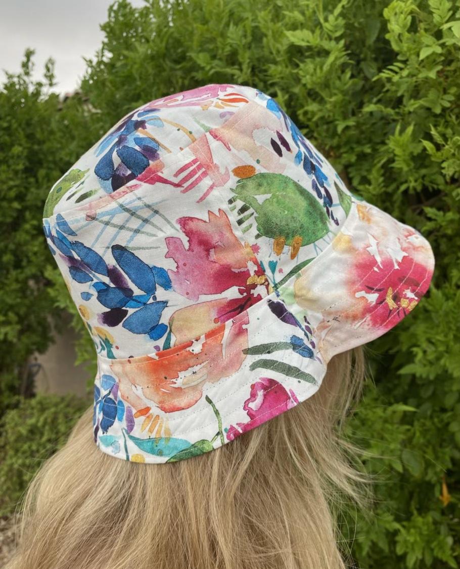 Side view of white side of hat, worn by adult woman 