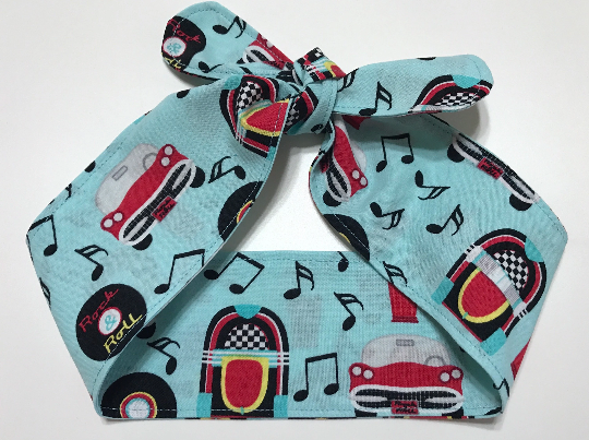 Fabic self tie 50's theme head band. Cars, records, music notes, jukeboxes, malts in black, yellow & red on aqua background