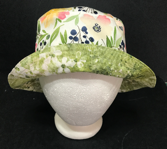 Front view with brim turned up to show light green subtle floral print on reverse