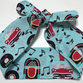 Fabic self tie 50's theme head band. Cars, records, music notes, jukeboxes, malts in black, yellow & red on aqua background