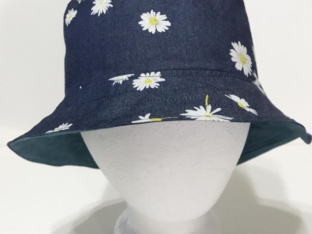 Front view, denim bucket hat with scattered small white daisies print